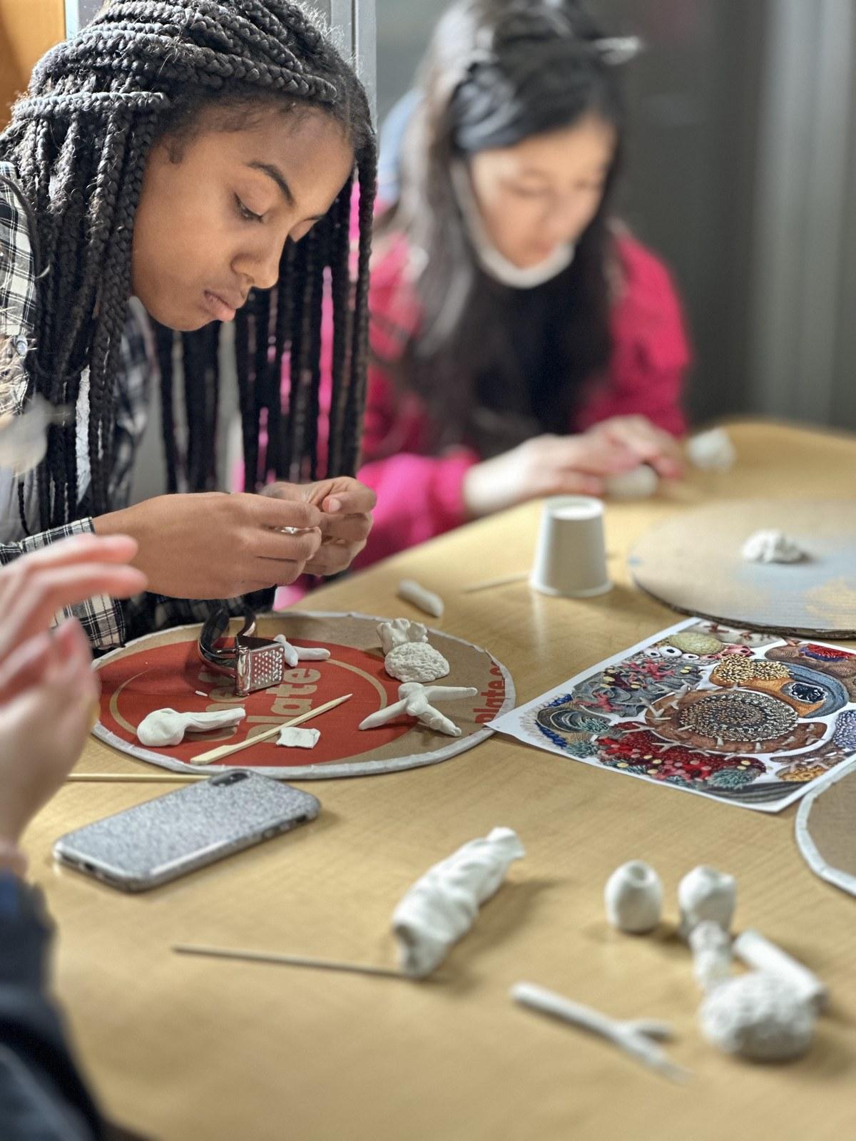 Grade 6 and 7 students shape clay sea creatures during a Reach to Teach: Immersed in the Arts session at The Arts Connection.
