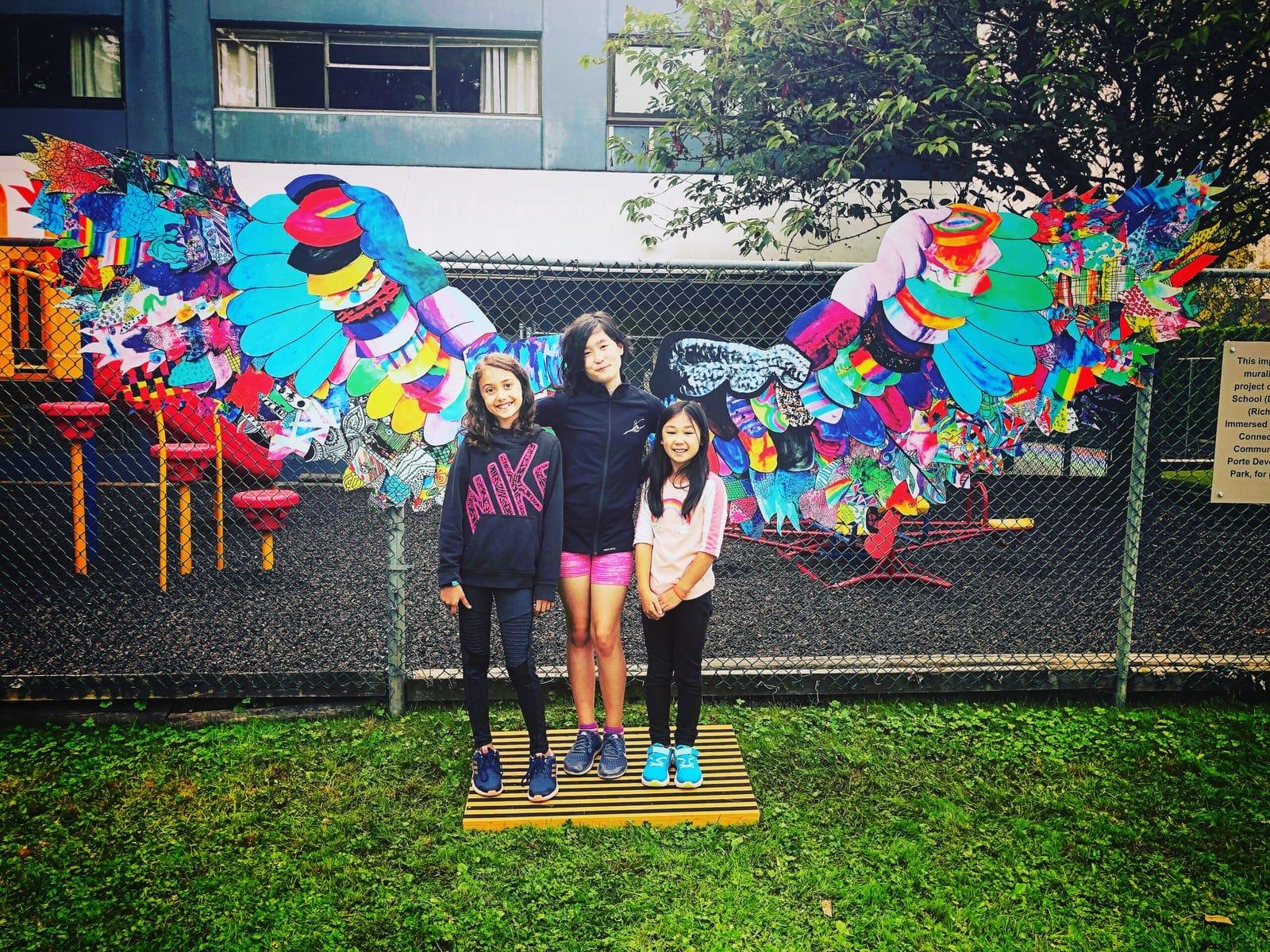 Students beside the Wings Project installation from Reach to Teach